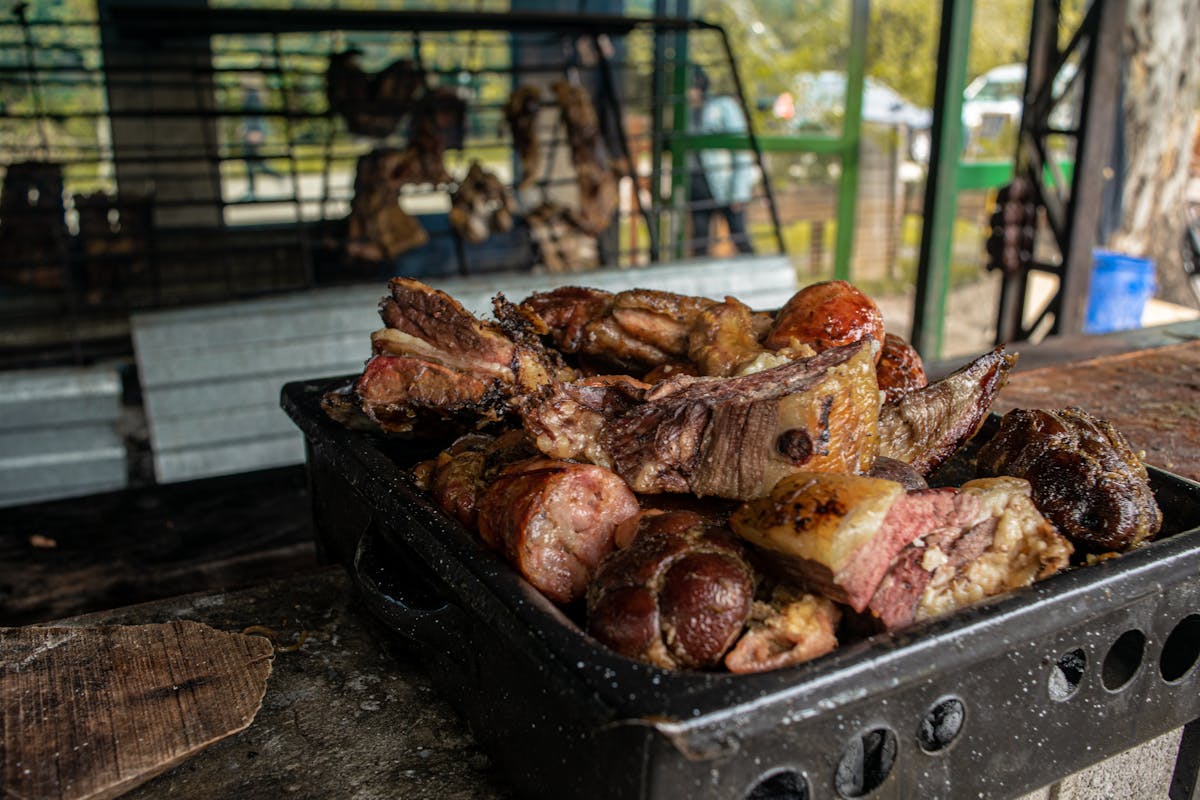 A rustic barbecue platter of smoked and grilled meats, the kind of presentation that highlights brisket burnt ends from the point